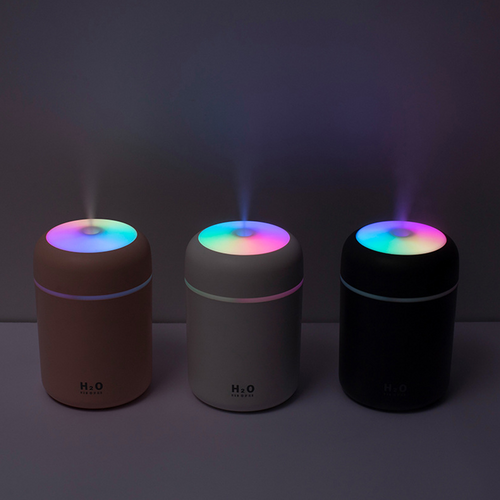 Three colorful humidifiers on a dark background